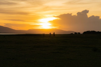 Scenic view of silhouette field against sky during sunset