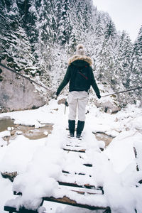 Rear view of man walking on snow