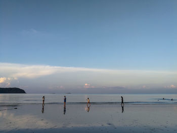 People on beach against sky