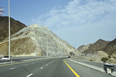 Road by mountain against sky