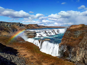 Scenic view of waterfall against sky