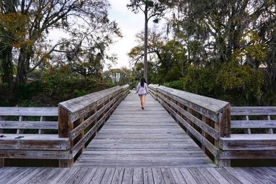 Rear view of man relaxing on footbridge