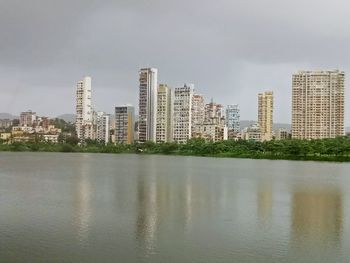 River by buildings against sky in city