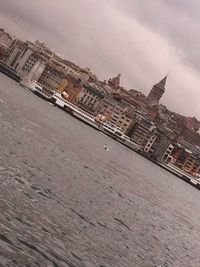 Buildings in city against cloudy sky