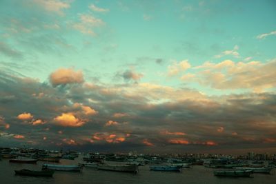 Boats moored on sea against sky during sunset