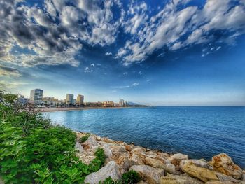 Scenic view of sea by buildings against sky