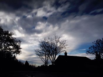 Low angle view of bare tree against cloudy sky