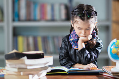 Portrait of boy with books on table