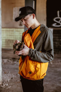 Man holding camera while standing on mobile phone