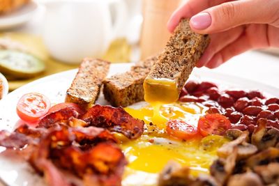 Close-up of hand eating food in plate