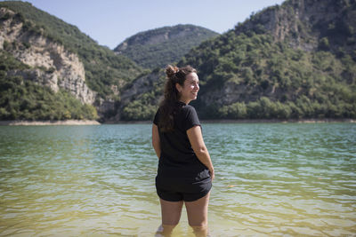 Full length of young woman standing on mountain