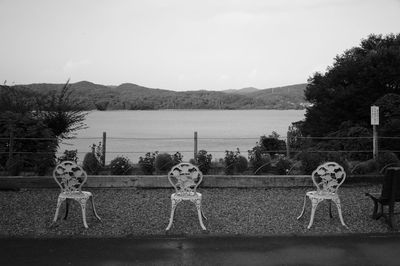 Scenic view of lake against clear sky with garden chair