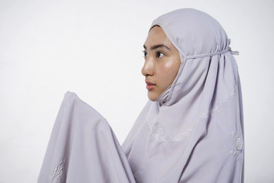 Portrait of young woman against white background