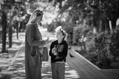 Mother and daughter on a walk, look at each other, against blurred background