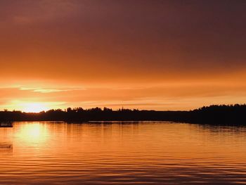 Scenic view of lake against orange sky