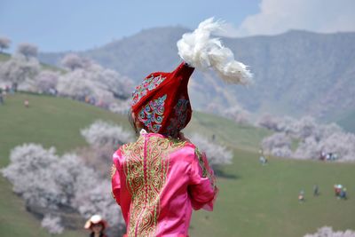 Rear view of woman wearing pink traditional clothing against mountain