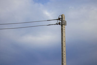 Low angle view of electricity pylon against sky