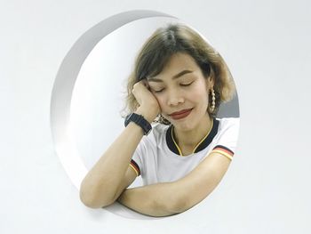 Portrait of smiling young woman against white background