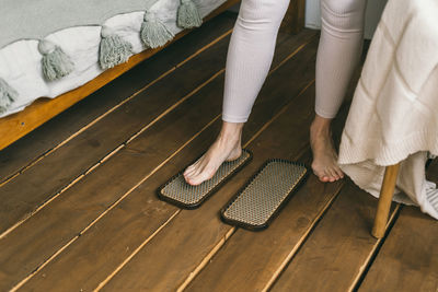 Low section of woman standing on hardwood floor