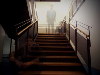 Low angle view of woman sitting on staircase in building