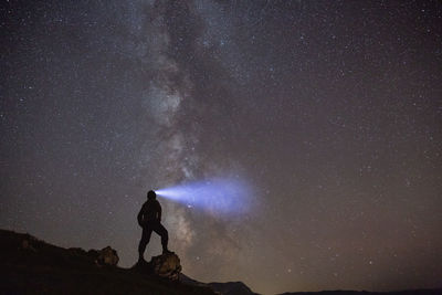 Silhouette man standing against sky at night