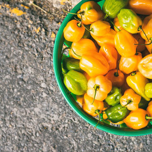 Close-up high angle view of bell pepper in basket for sale