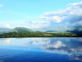 Swimming pool by sea against sky