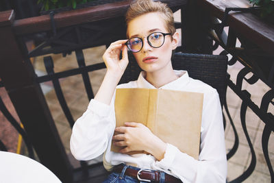 Portrait of beautiful young woman sitting in eyeglasses