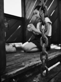 Close-up of chain with girl in background