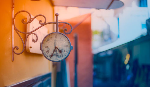 Close-up of clock hanging on wall outdoors