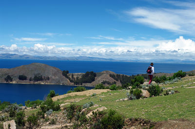 People standing on rock against sky