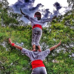 Rear view of man with arms outstretched against trees