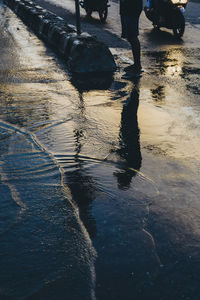 Low section of man reflection in puddle