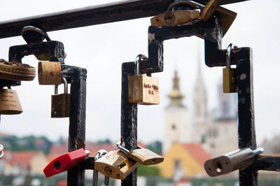 Close-up of padlocks hanging on metal against sky