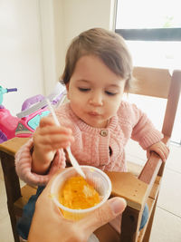 Portrait of boy eating food at home