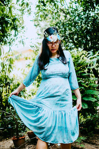 Beautiful young woman standing against trees