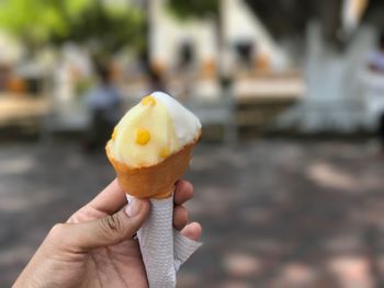 Close-up of hand holding ice cream cone