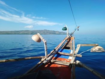 Fishing boat in sea against blue sky