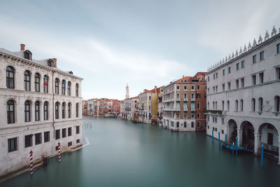 Canal amidst buildings against sky