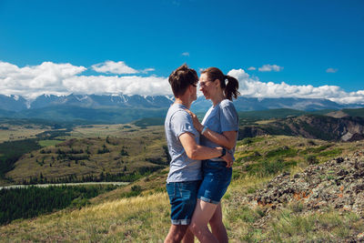 Full length of woman standing on mountain against sky