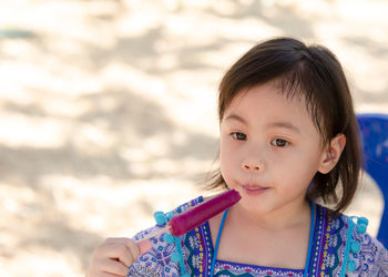 4 years old cute baby asian girl, little toddler child with beautiful eyes eat ice cream. copy space