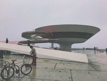 Bicycle against modern building in city against sky