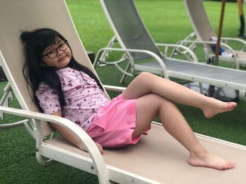 Full length of girl sitting on lounge chair