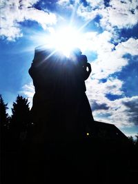 Low angle view of silhouette statue against sky