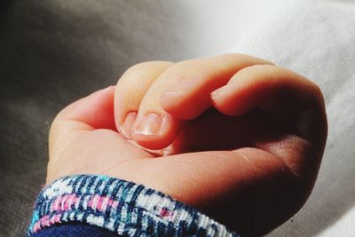 Cropped hand of child against wall