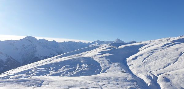 Scenic view of snowcapped mountains against clear blue sky