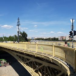 Bridge over river in city against sky