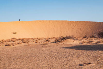 A tourist standing on a beautiful sand dune at north horr sand dunes in marsabit county, kenya