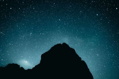 Low angle view of silhouette man against star field at night