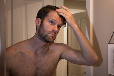 Portrait of shirtless man in bathroom